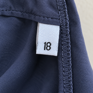 White women’s woven size 18 label sewn into the side seam of a navy garment