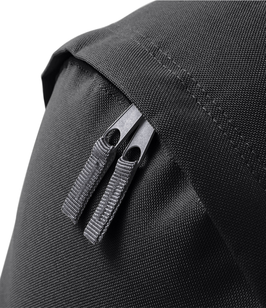Close-up of the black children’s backpack showing the main compartment’s twin zip pulls and textured fabric.