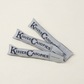 Three grey custom woven zipper pulls branded Kinver Canopies on a white background