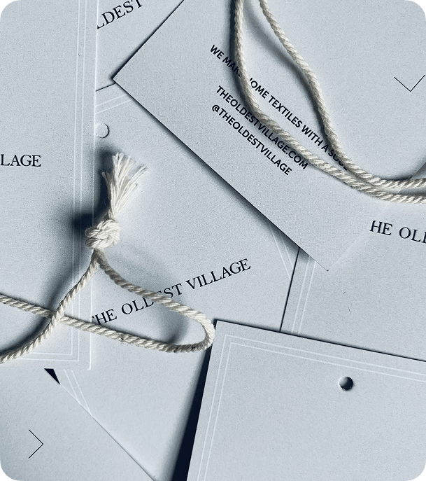 Close-up of custom printed grey silk swing tags with white string and black branding