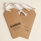 Two custom printed kraft swing tags with KAIROS branding and white cord attachments