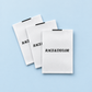 White custom printed satin clothing labels with black branding on a pale blue background