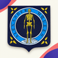 Custom-shaped Alexander McQueen woven badge with blue and gold skeleton design