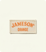 Custom cream woven fabric badge with orange Jameson lettering