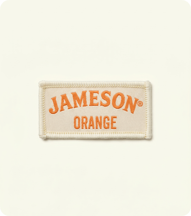 Custom cream woven fabric badge with orange Jameson lettering