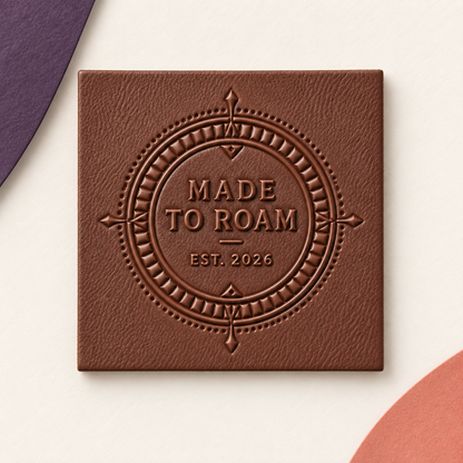 Square brown custom leather label with an embossed Made to Roam compass design