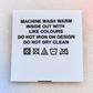 White printed satin care label with washing instructions and laundry care symbols