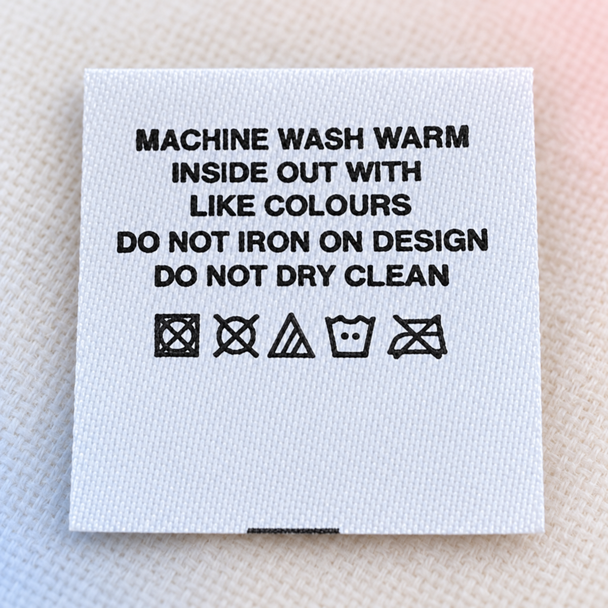 White printed satin care label with washing instructions and laundry care symbols